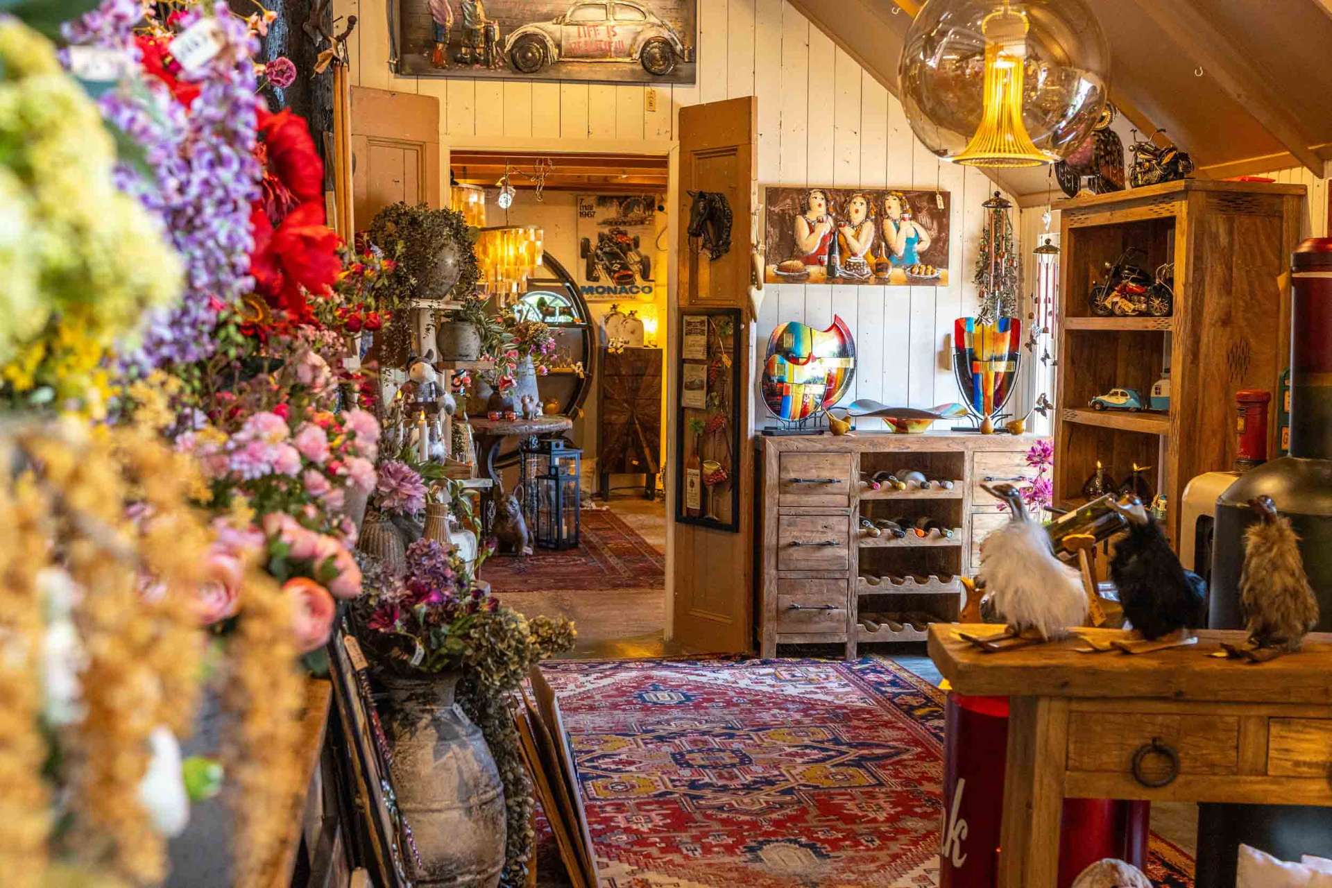 Sfeervol interieur van de woonboerderij met bloemen, glaskunst en decoratie