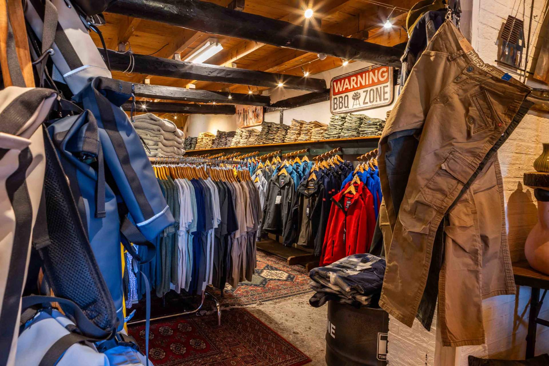 Overzicht van de kledingwinkel met rekken vol jassen en shirts